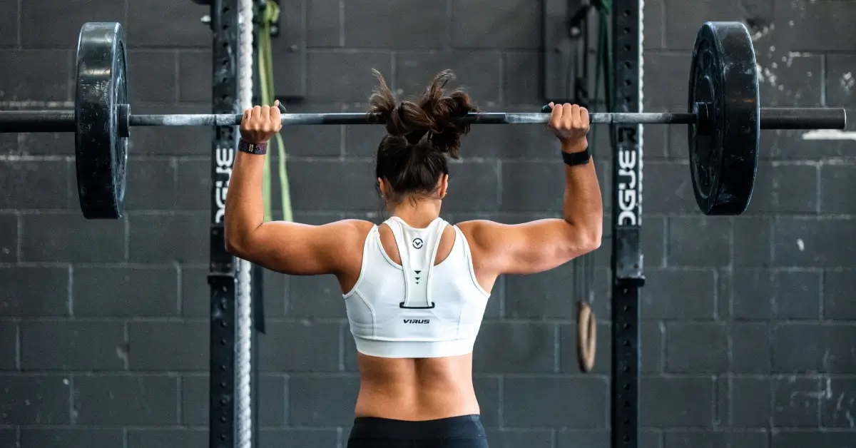 pre workout itch for woman in gym lifting barbell